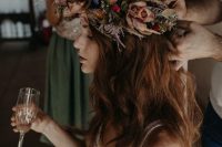 a moody floral crown with rust, blue and red blooms, dried foliage and grass for a beautiful fall bridal look