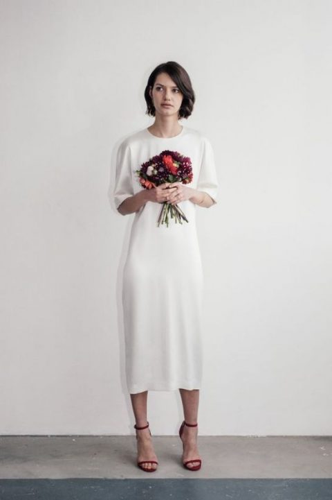a plain white silk wedding dress with short sleeves and a high neckline plus red heels for an accent
