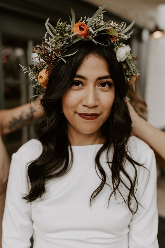 a pretty and bold floral crown with white, orange blooms, small fillers and greenery for a fall boho bridal look