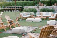 a relaxed rustic outdoor lounge with neutral upholstered furniture and wooden chairs, printed rugs and poufs and cushions
