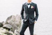 a retro groom’s look with a navy windowpane print suit in three pieces, an aqua shirt, a blue bow tie and brown shoes