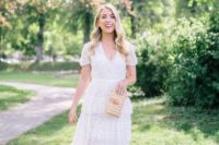 a romantic A-line midi dress with a tiered skirt with ruffles, short sleeves and a cutout neckline, nude heels and a wicker clutch