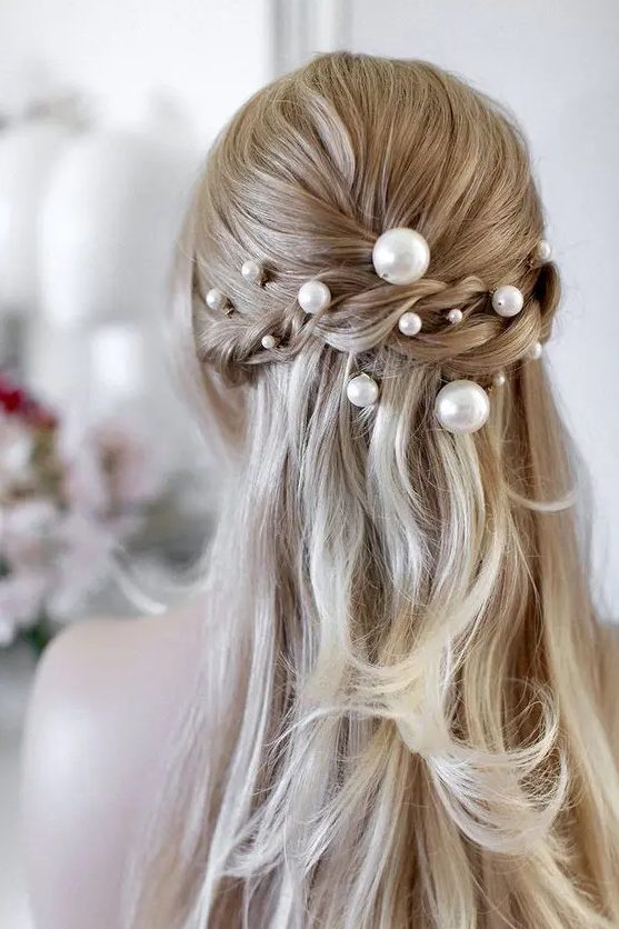 a romantic half updo with a braided halo and pearl pins of various sizes - smaller and larger ones