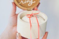 a round wooden box with calligraphy and your rings in it is a cool idea for a modern or cozy casual wedding