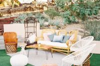 a simple and bright boho wedding lounge with rattan furniture, pastel pillows, leather poufs, a hairpin coffee table