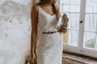 a simple modern look with a white spaghetti strap top, a lace skirt, a metallic belt and a clutch