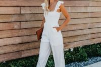 a stylish white jumpsuit on ruffle straps, dusty pink shoes and a brown clutch for a simple and chic look