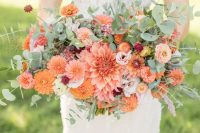 a super bold and cool wedding bouquet of orange dahlias, burgundy and blush blooms and lots of greenery