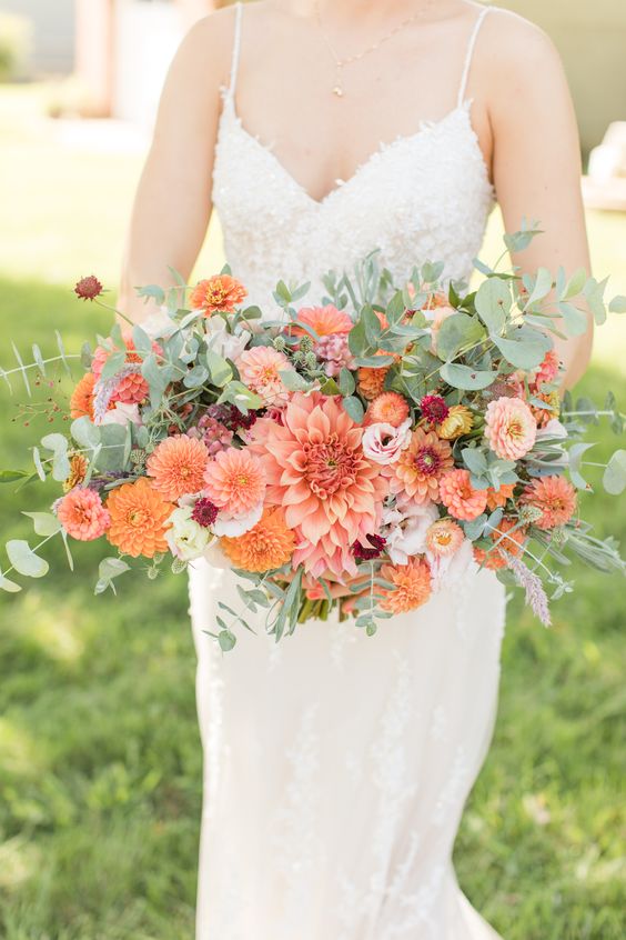 a super bold and cool wedding bouquet of orange dahlias, burgundy and blush blooms and lots of greenery
