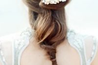 a twisted and relaxed bridal ponytail with a pearly hairpiece for a beach bride who is looking for elegant and sleek styles