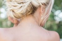 a twisted low bun with some locks down, with locks framing the face is a gorgeous idea  for a chic and elegant look not only at a beach wedding