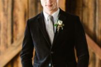 a vintage-inspired groom’s look with tan pants, a neutral shirt, a grey tie and a black velvet blazer