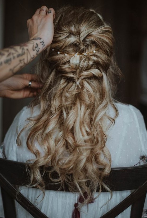 a wavy twisted half updo with a messy top, a pearl headband and waves down is a chic and romantic idea