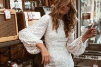 a white sequin mini dress with a high neckline, puff sleeves and statement earrings for a fun-loving bride