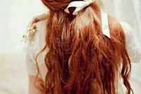 long wavy red hair with a poytail incorporated and a creamy bow for a romantic bride with very long hair who wants to show off her locks