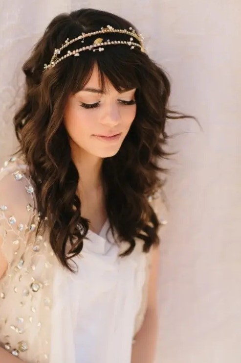 medium length waves down with a touch of mess plus bangs and a sparkling headpiece