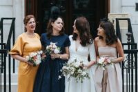 various vintage-inspired midi bridesmaid dresses in neutrals, yellow and navy, with mismatching shoes