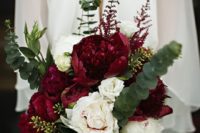 a beautiful fall wedding bouquet of burgundy and white blooms and greenery