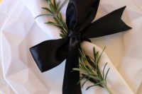 a black ribbon bow with a herb twig is a chic idea for a modern wedding and it refresh the tablescape a lot