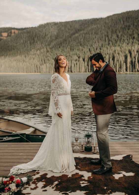 a boho lace A-line wedding gown with a V-neckline, bell sleeves and a train for a lake boho elopement