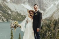 a boho lace high low wrap wedding dress with bell sleeves and a train for a mountain and lake elopement with a wild feel