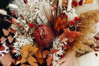 a bold fall wedding bouquet of rust and burgundy blooms, bold fall foliage, fronds, bunny tails and grasses is fantastic