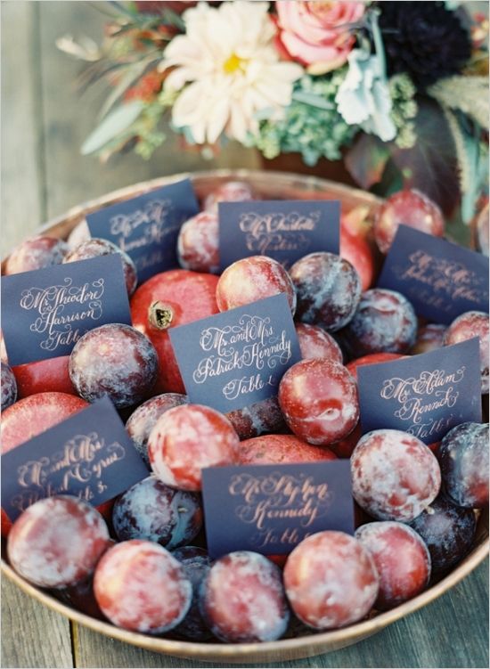 a bowl with plums and seating cards is a nice display idea that will please everyone