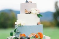 a bright fall wedding cake with a blush, white and blue tier, blooms and figs is a laconic and chic idea