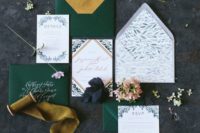 a bright wedding invitation suite with emerald envelopes and gold lining and botanical invites