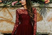 a burgundy lace wedding dress with an illusion neckline and long sleeves for a fall bridal look