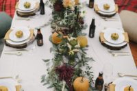 a casual outdoor fall wedding reception with greenery and burgundy blooms, pumpkins on plates and wooden slice chargers