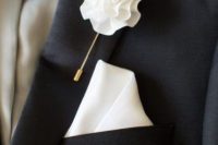 a chic and refined wedding boutonniere of a white fabric pompom and a gold pin is a lovely solution if you don’t want a real bloom