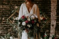 a chic art deco wedding gown with a plunging neckline, cape, train and floral embellishments is a very chic idea for a wedding