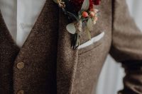 a chic brown tweed three-piece suit, a whiet shirt, a burgundy velvet bow tie and a floral boutonniere
