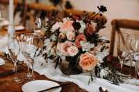 a chic fall wedding tablescape with neutral linens, a bright and white floral centerpiece, tall candles and elegant cutlery is amazing
