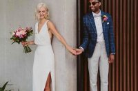 a chic minimalist wedding dress with no sleeves, a deep V-neckline, a draped bodice and a midi skirt with a slit plus pink shoes