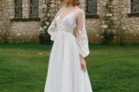 a chic vintage A-line wedding dress with a lace bodice and sleeves, a tulle layered skirt and a train, a deep V-neckline