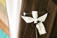a chic vintage wedding boutonniere wiht a key, a ribbon bow, a tag and an elegant pin is amazing for a wedding
