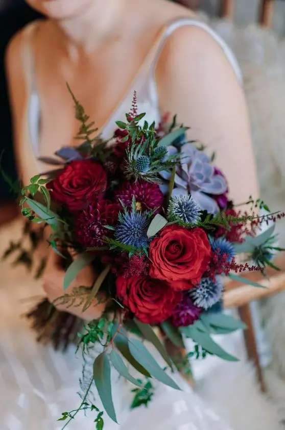 a colorful boho wedding bouquet in red, purple, with thistles and succulents looks super bold