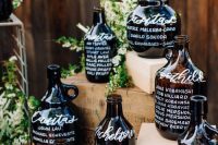 a cool wedding seating chart of oversized wine bottles and greenery is perfect for a vineyard wedding, not only a fall one