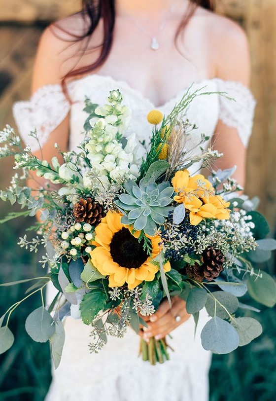 a creative summer wedding bouquet with woodland and farmhouse touches - with succulents, sunflowers, pinecones and billy balls is cool