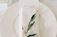 a delicate and refined neutral ribbon napkin ring with a greenery twig is a very stylish and chic idea for a modern elegant wedding