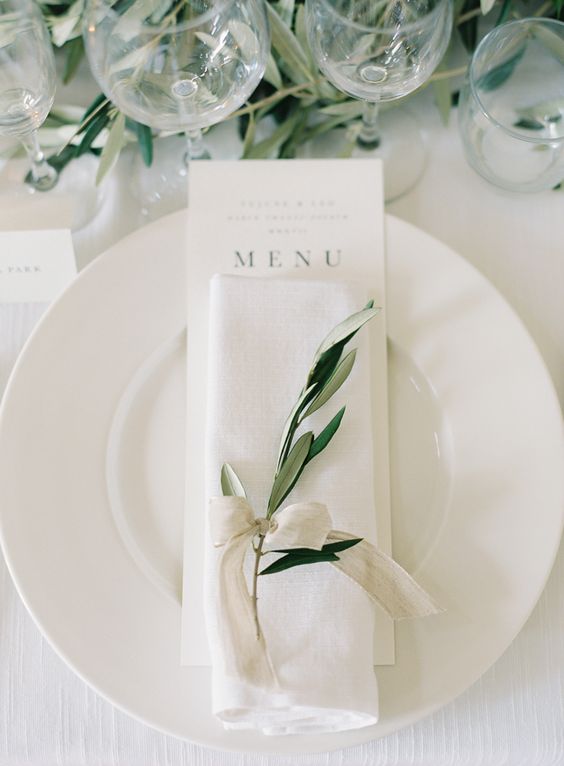 a delicate and refined neutral ribbon napkin ring with a greenery twig is a very stylish and chic idea for a modern elegant wedding