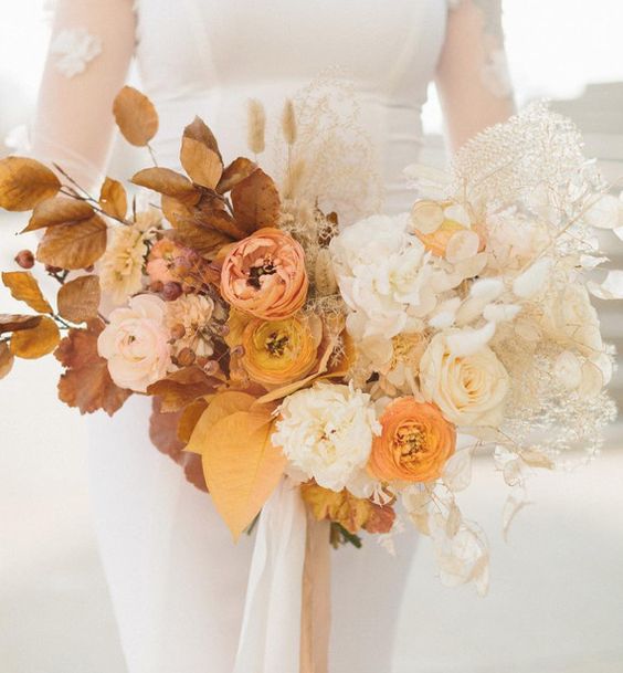 a fab ombre wedding bouquet from rust tp peachy and blush, yellow marigold and white, with foliage, bunny tails, leaves is amazing for a modern fall wedding