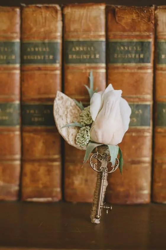 a fab vintage wedding boutonniere of a blush rose, greenery and a vintage key is a great groom's accessory