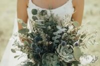 a fantastic greenery wedding bouquet with succulents, thistles and eucalyptus plus grasses for a woodland wedding