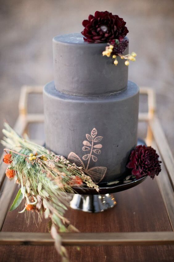 a grey fall wedding cake with copper patterns and dark blooms plus dried herbs and blooms