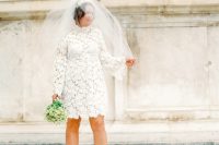 a lace A-line wedding dress with a turtleneck, long sleeves, nude shoes and a veil for a retro-inspired bride