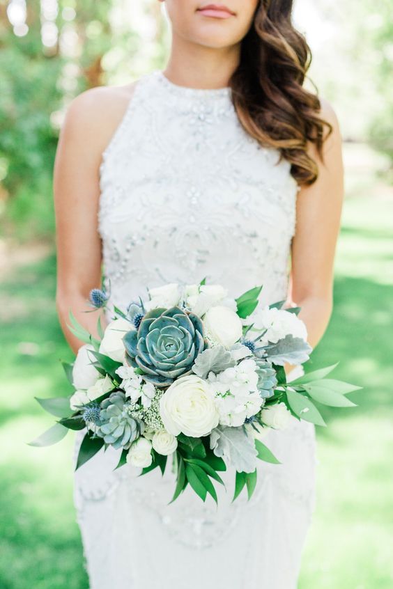 a laconic wedding bouquet of white ranunculus, greenery, succulents and blue thistles is a gorgeous idea for spring