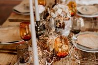 a lovely wedding tablescape with amber glasses, copper cutlery, grey glasses and plates and dried blooms and leaves